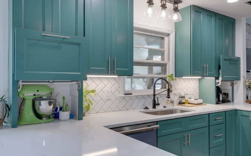 Image of a seafoam green kitchen with white subway tile backsplash and white countertops